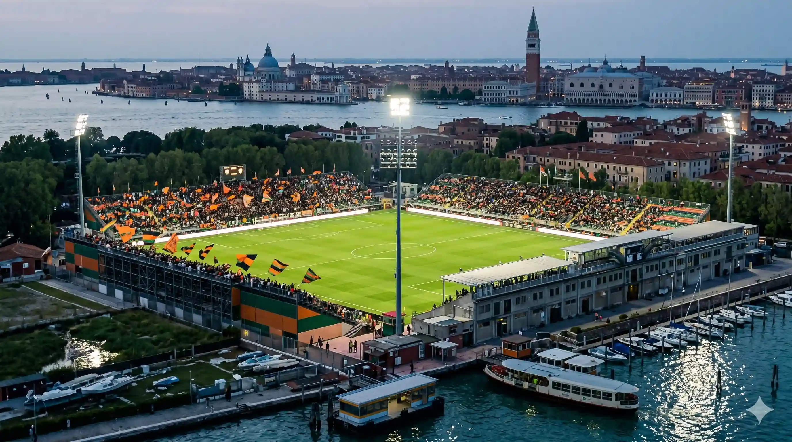 Tifosi Venezia arancione e nero allo stadio Pier Luigi Penzo di notte.